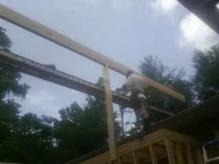 Carpenter setting a ridge beam over a new addition frame — Ice Dam Removal by Roofing Brothers in Orford