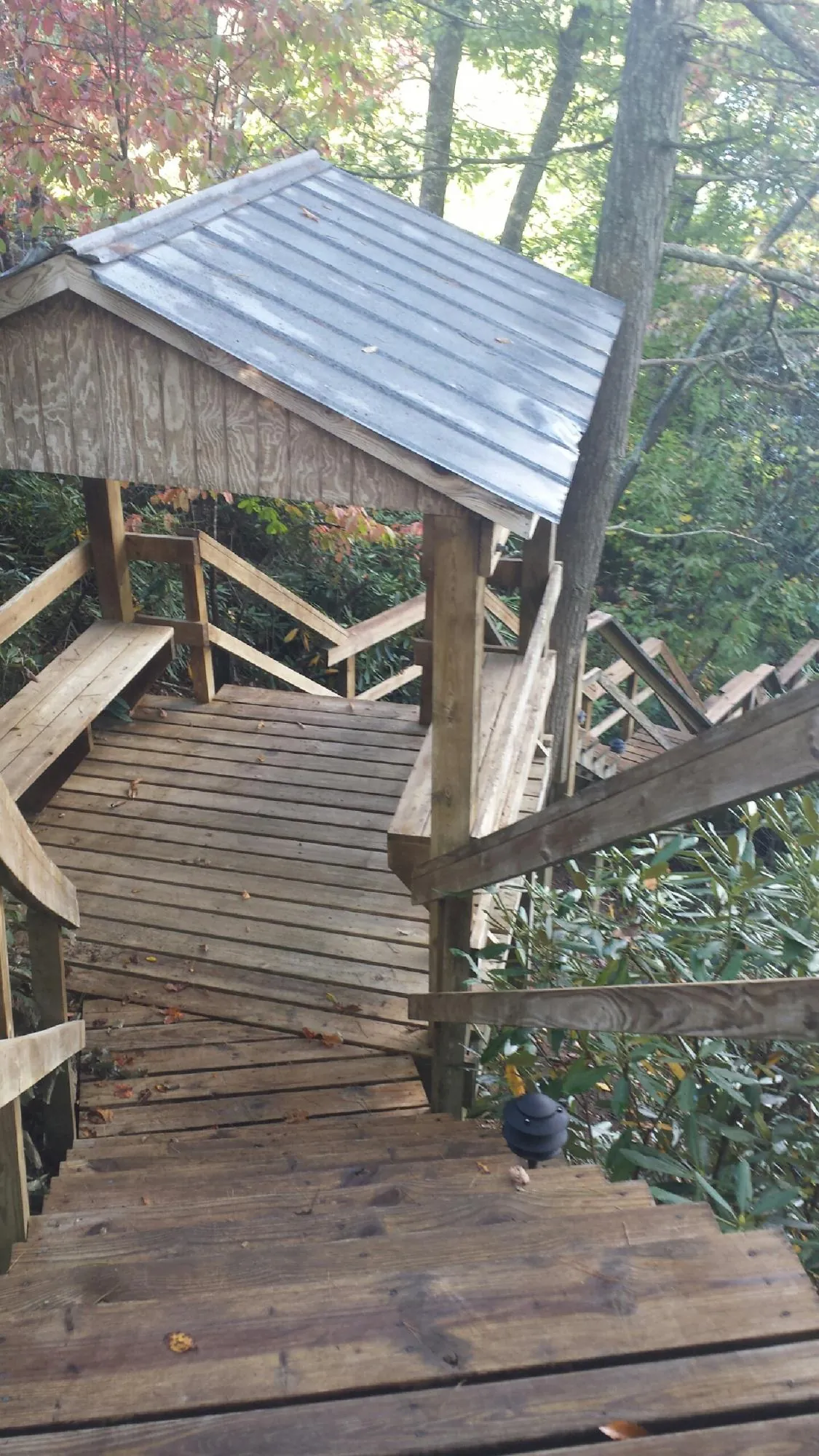 Metal roofed shelter over wooden steps on a wooded walkway — Skylight Repair & Installation work by our crew in Orford